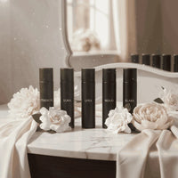 Thumbnail for Women’s luxury perfume discovery set displayed on a marble vanity with soft florals